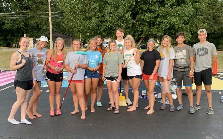 kids with painting tools in a parking lot